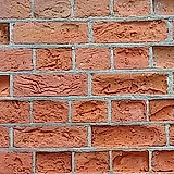 Eroded mortar joints between weathered red bricks