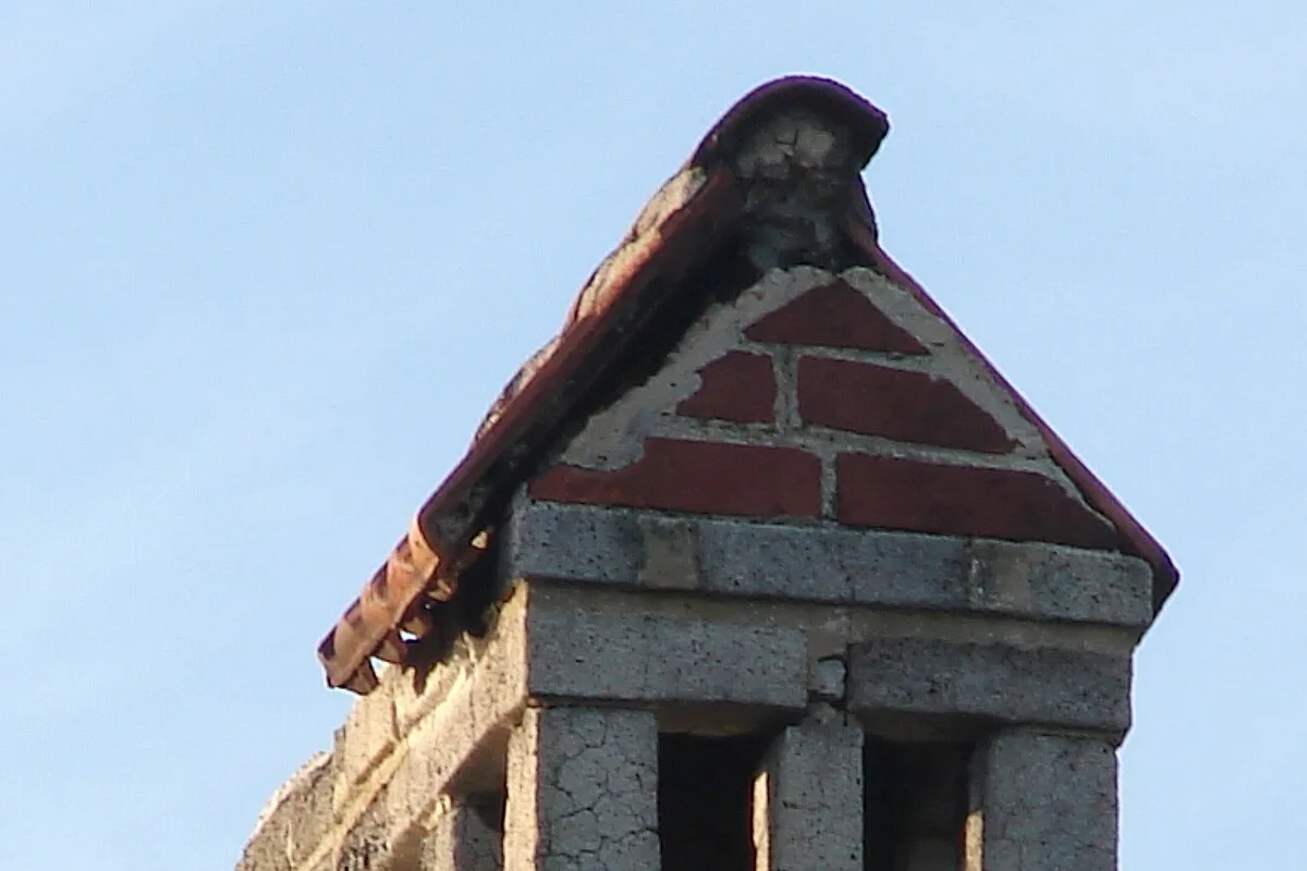 Weathered masonry chimney top with a cracked crown